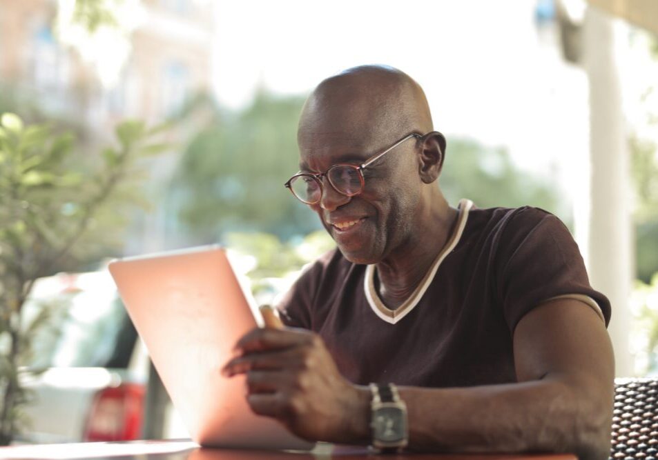 mature man with a tablet in an outdoor cafe